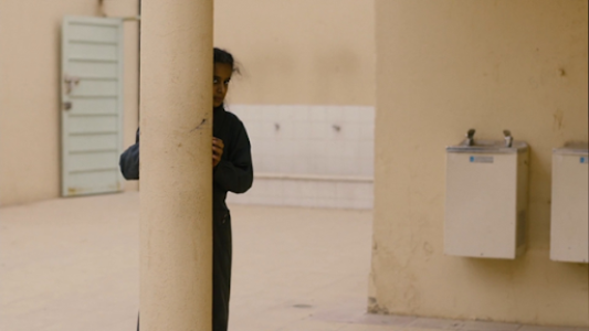 Dans la cour de récréation, elle observe Mme Hessa réprimander Fatin et Fatima, accusées de commettre un péché.